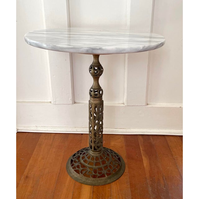This vintage pierced brass side table features a Carrara marble top. The brass is beautifully aged & piece is in solid...