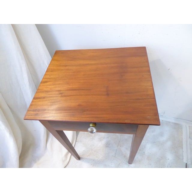 This American mahogany stand has a single dovetailed drawer with a glass handle.