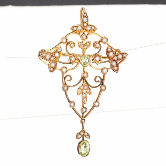 Finely detailed antique Edwardian pendant (circa early 1900s), crafted in 9k yellow gold. Peridot measures 4mm and 5mm x...
