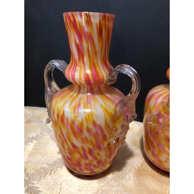 A pair beautiful hand blown Italian multi colored art twin handled glass vases. an array of abstract murrina make up these...