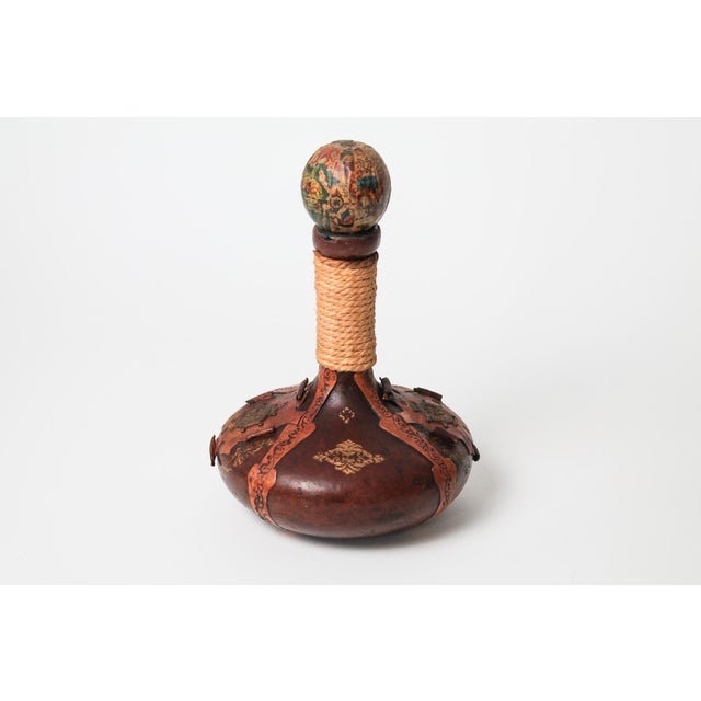 Vintage nautical themed hand tooled leather wrapped decanter. Made in Italy. Some age wear to leather and gold paint. The...
