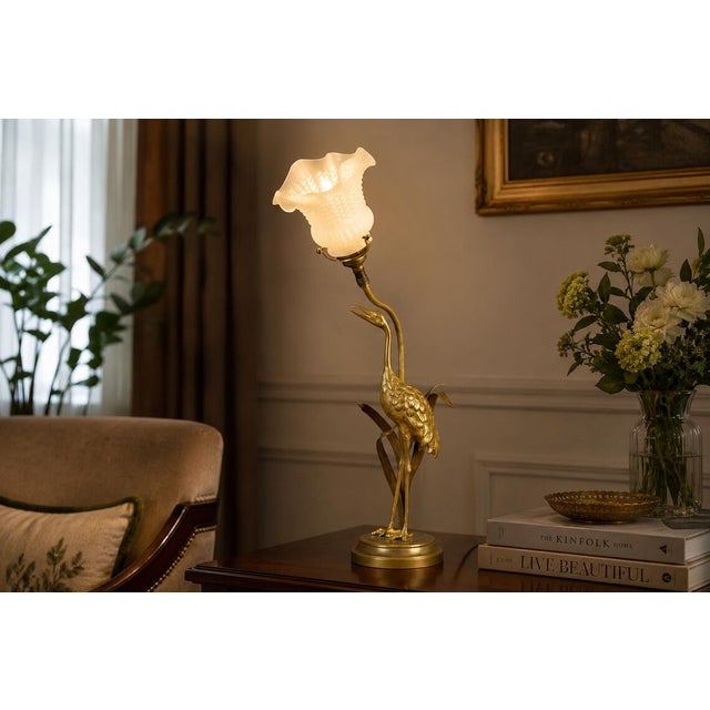 A truly exceptional and highly decorative table lamp, featuring a naturalistic sculpted crane in gilt brass standing tall...