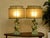 A striking pair of vintage table lamps featuring sculptural figural bases paired with distinctive double-panel shades....