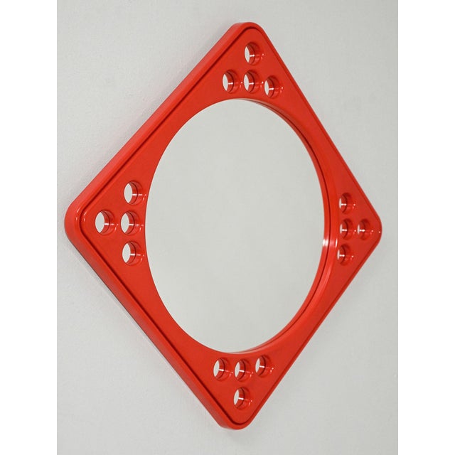 Scandinavian mirror in red plastic with a perforated geometric frame, produced by Makiesen Kuvastin Oy. Graphic design...
