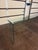This minimalist console table is crafted from a single sheet of thick, bent glass, forming a clean waterfall silhouette...