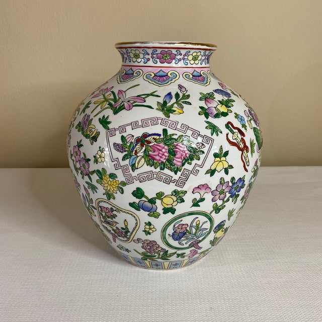 Floral vase with a gold rim and multiple vibrant hand painted colors with a white background.