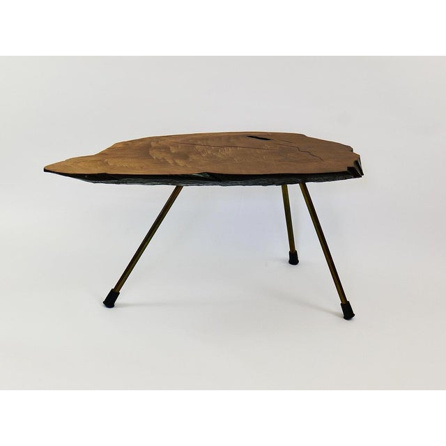 A organic and sculptural original vintage tree trunk sofa table from the 1950s, designed and executed by Carl Auböck. This...