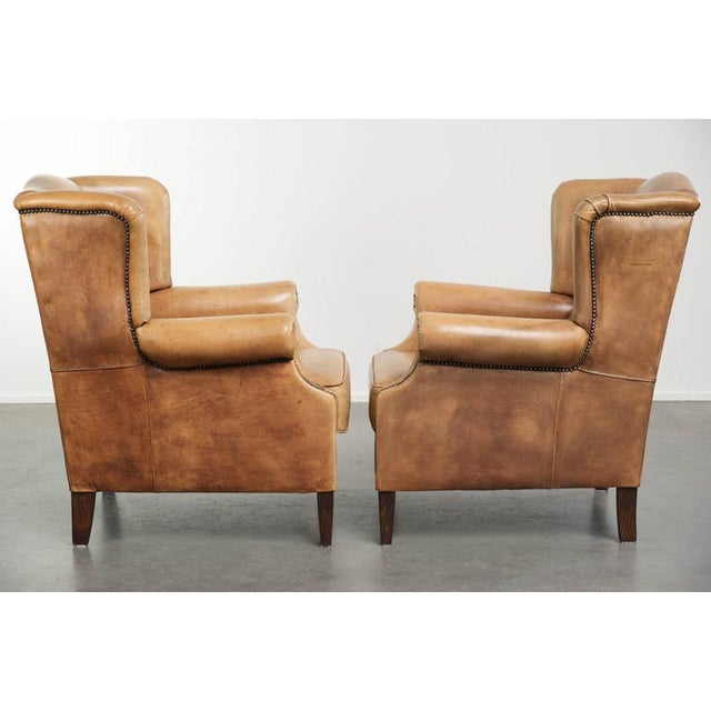 Offered by ByThijs is this set of two beautiful light cowhide wing armchairs with a timeless English look and excellent...
