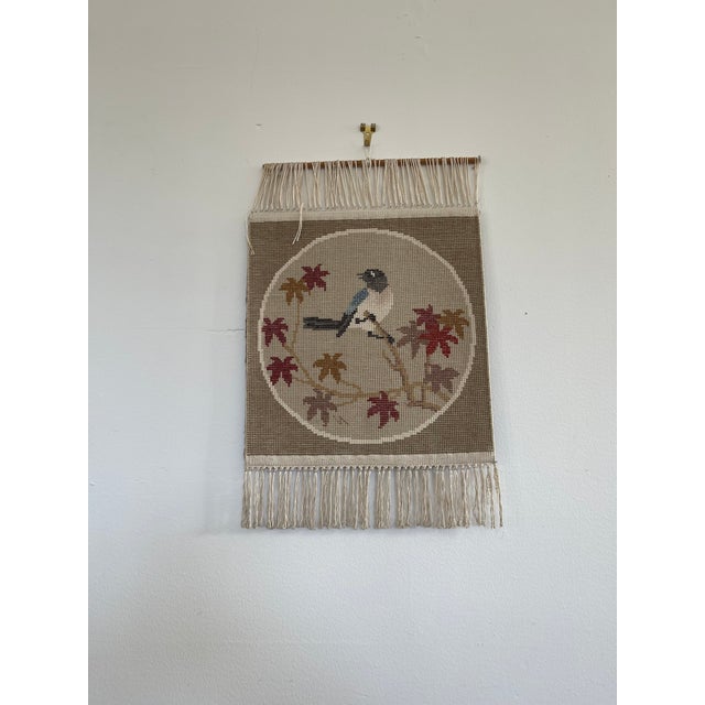 Beautiful vintage textile wall hanging featuring a hand-tufted design of a bird perched on a branch surrounded by autumn-...