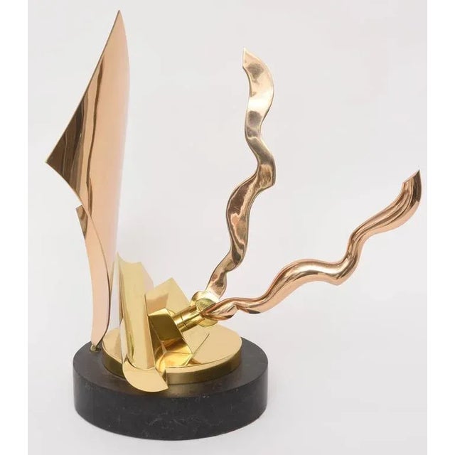 This mixed-metal sculpture has a substantial look to it with its free-form design. The two curved-arms move and can be...