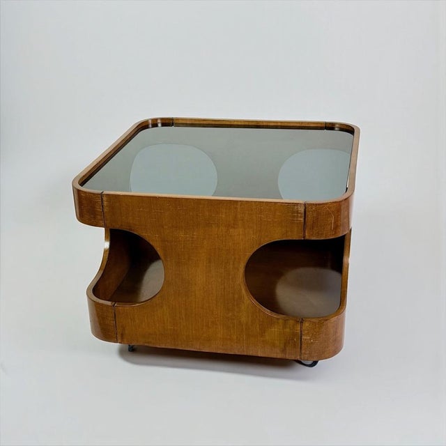 Sculptural coffee table produced in Italy during the 1970s. The piece features a curved wood structure with large circular...