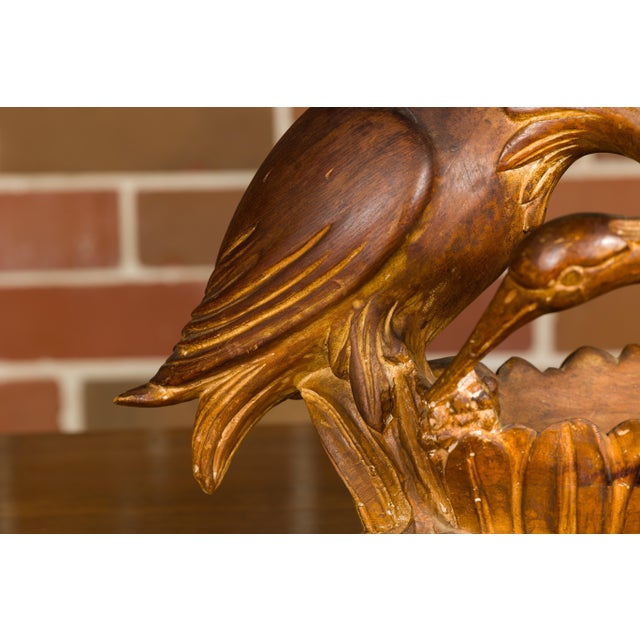 An Italian carved wooden bowl from the mid 20th century with crane and foliage motif. This mid-20th-century Italian carved...