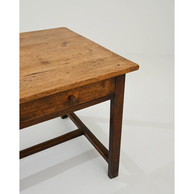 A wooden side table created in 1900s France. Simple, unassuming, and possessing a quiet disposition, the elegantly minimal...