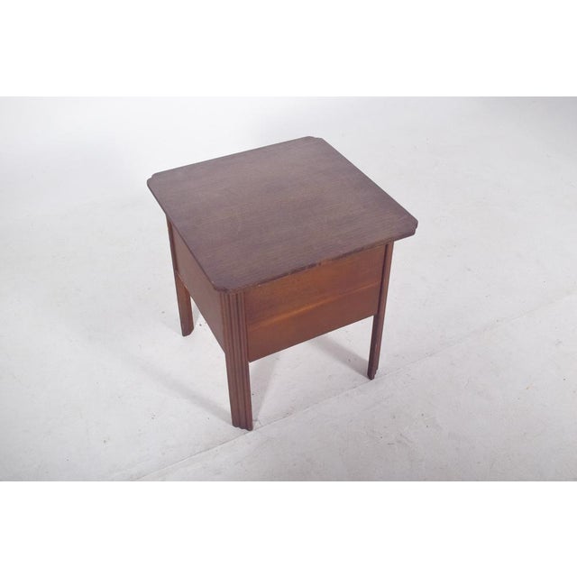Sewing table. Made of wood, it has a quadrangular structure with a hinged top that opens to reveal an interior lined with...