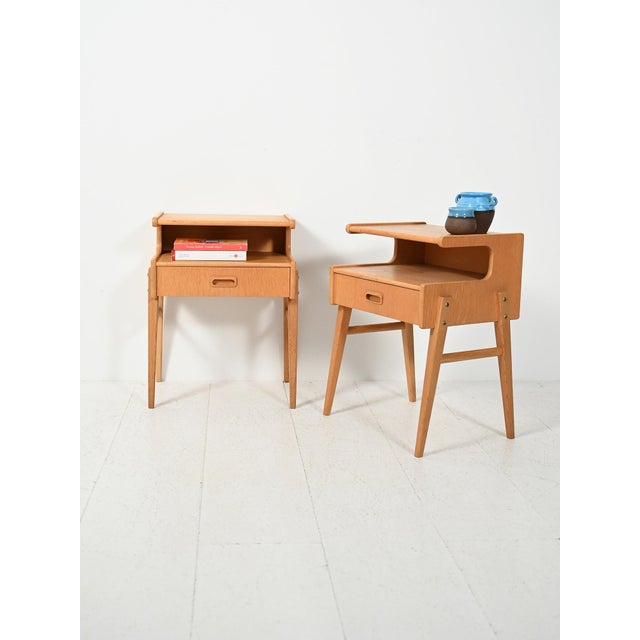 Pair of 1960s Scandinavian oak bedside tables, featuring a contoured frame with a double shelf and light proportions. Pair...