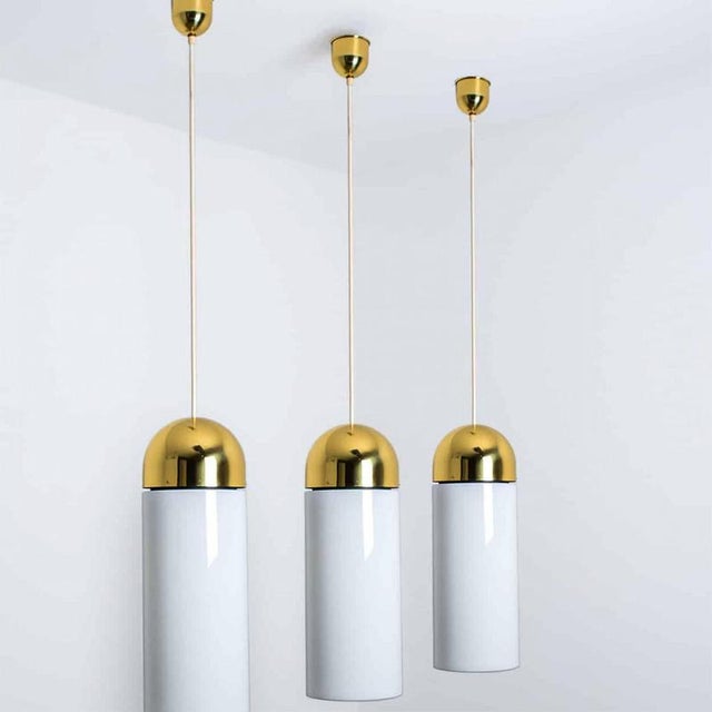 A wonderful round brass chandelier, circa 1970, made by glashütte limburg, germany. With thick hand-blown white glass with...