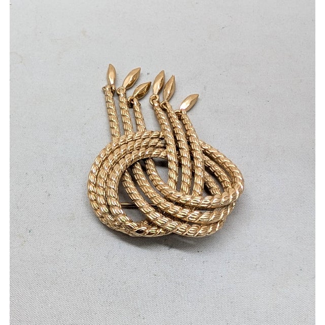 1960s goldtone textured knot with 6 drops at the bottom fringe brooch with security clasp. Marked "MONET©" on the back....