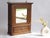 An antique wooden cabinet in Art Deco style with a rectangular mirror in the front door. The apothecary is made out of...