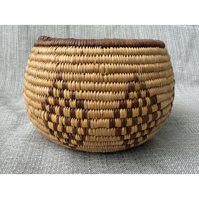 Small vintage, fine woven geometric coil basket. Simple dark brown rim and diamond shapes around the sides against a...