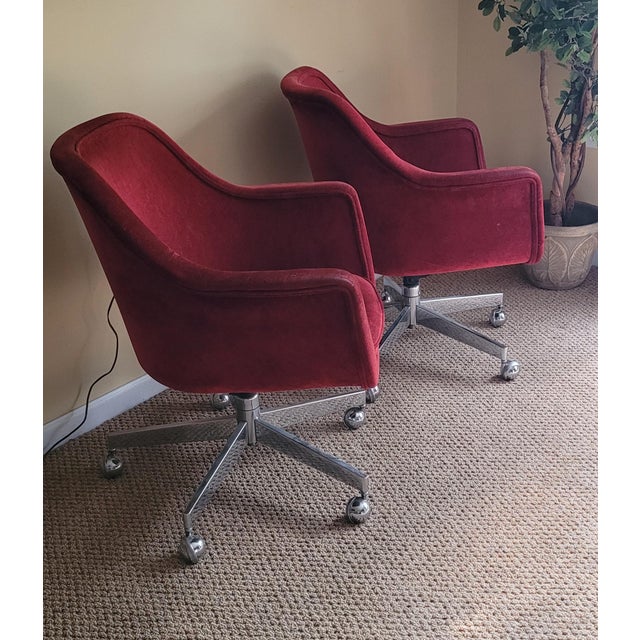A nice pair of mid-century modern burgundy swivel tulip chairs. Featuring a corduroy like material minor wear to the arms...