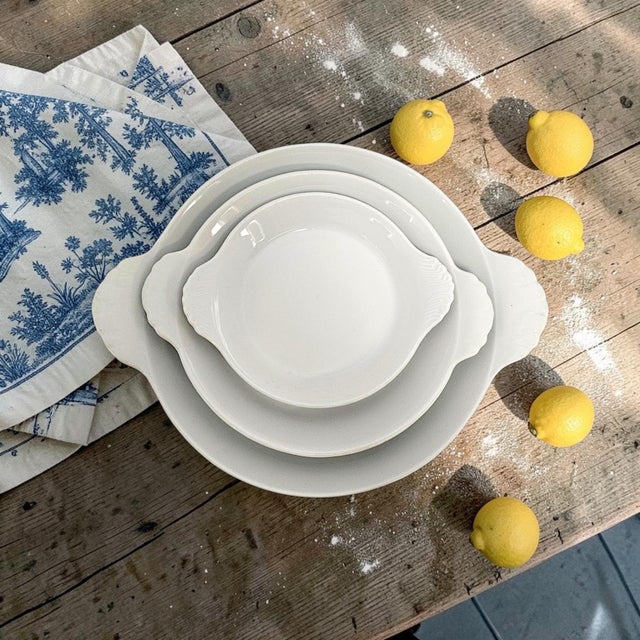 A graduated pair of Pillivuyt France round au gratin baking dishes, produced in France during the late twentieth century...