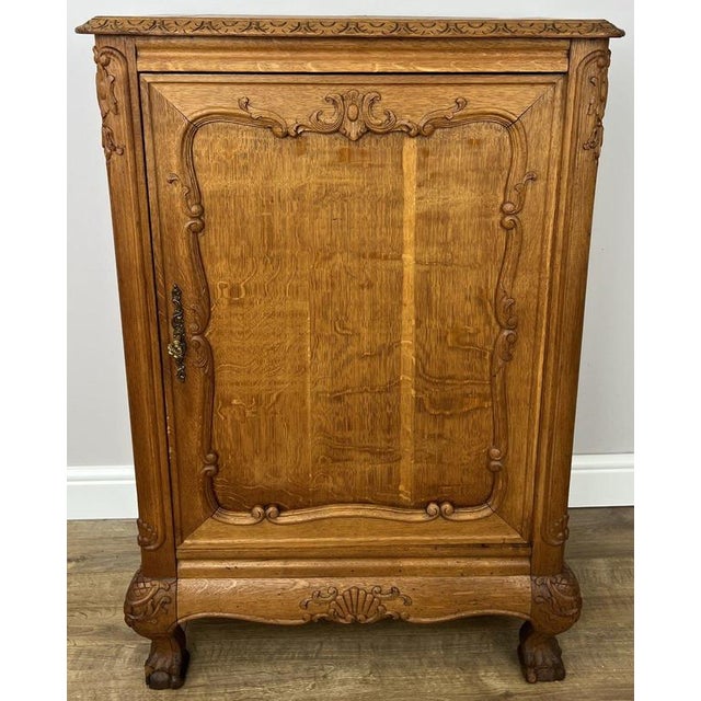 This elegant Vintage French cabinet showcases beautifully carved detailing, a warm oak finish, and classic period styling...