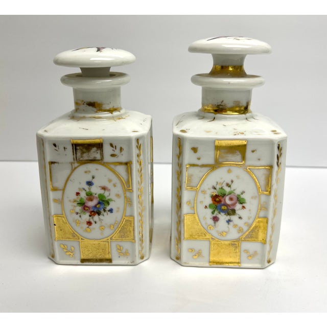A pair of porcelain bottles and stoppers. White porcelain with polychrome decoration action of flowers and butterflies.