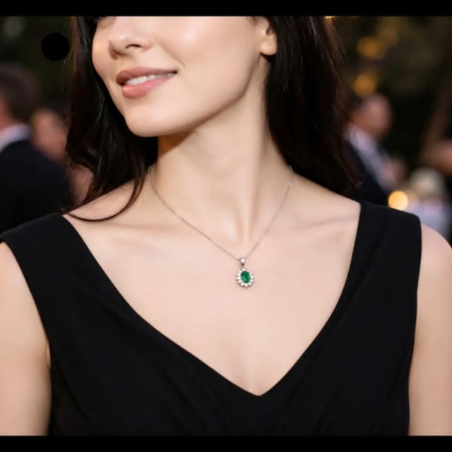 Elegant 14K white gold necklace featuring a natural oval-shaped emerald accented with 12 brilliant round diamonds. Estate...
