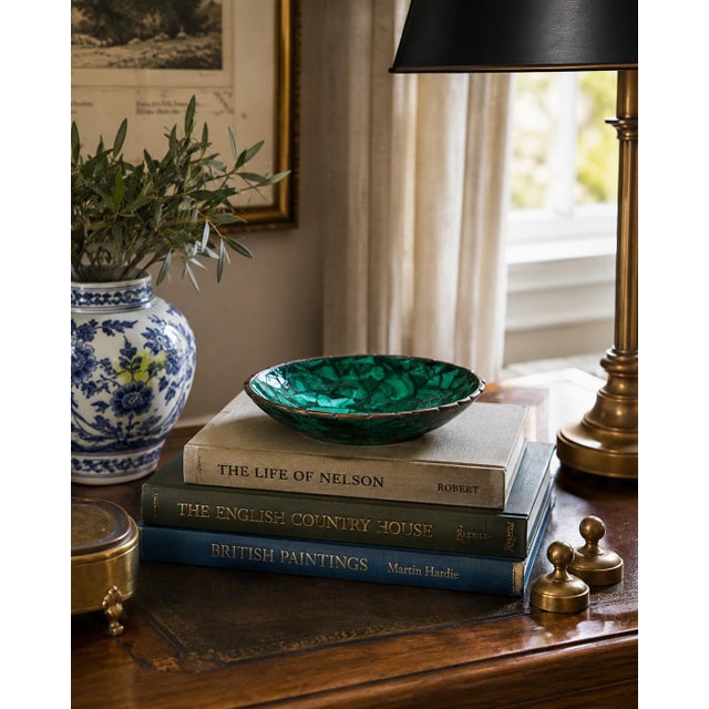 A beautifully proportioned brass rimmed malachite bowl in richly veined shades of green and black. The sculptural...
