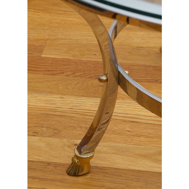 Elegant 1970s Italian coffee table featuring a sculptural polished chrome frame with brass cloven hoof feet, brass...