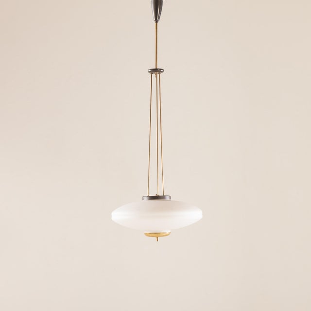 This elegant Italian mid-century disc lamp comes from the 1960s and closely resembles the style of Pietro Chiesa designs...