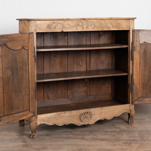 Early 19th century tall French sideboard crafted in oak and finished with a bleached surface that gives the wood a lighter...