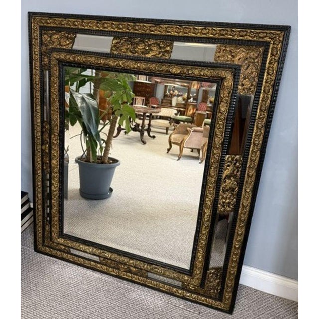 This large, ornate mirror features a stunning bevelled edge that adds depth and dimension to the reflective surface. The...