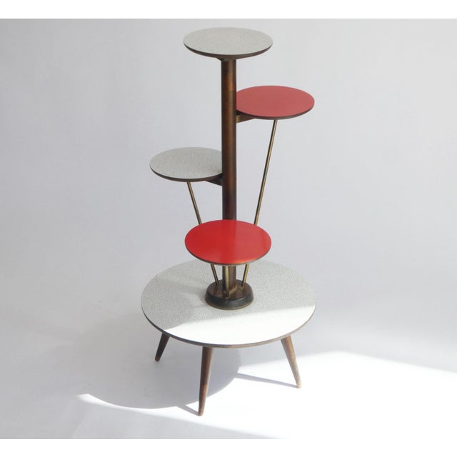 An original vintage wooden plant stand from the 60's with round red and white coloured tiers. The tiers are connected to...