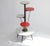 An original vintage wooden plant stand from the 60's with round red and white coloured tiers. The tiers are connected to...
