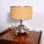 Lamp with white ceramic sculpture painted silver and gold. Chrome-plated brass rod. Oval fabric lampshade with two gold-...