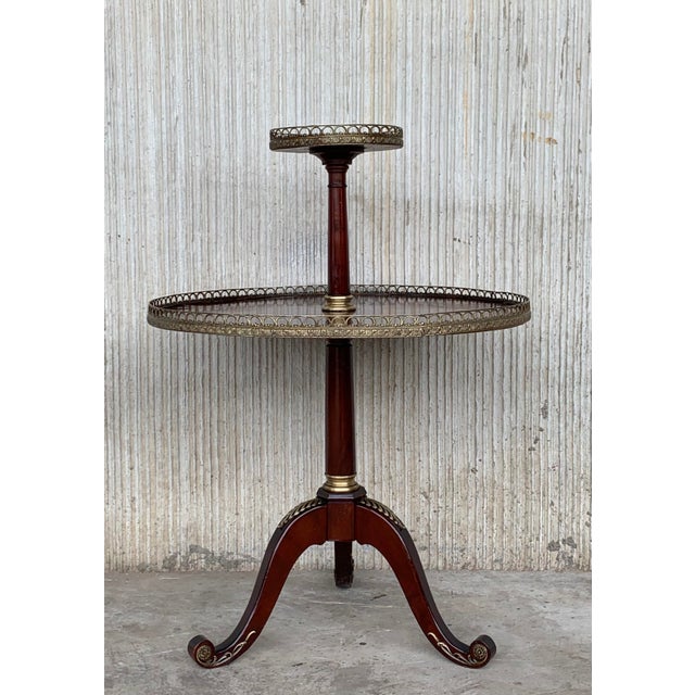 Louis XVI style two-tiered side table from France featuring a sun marquetry on the bottom shelf. Both feature brass...