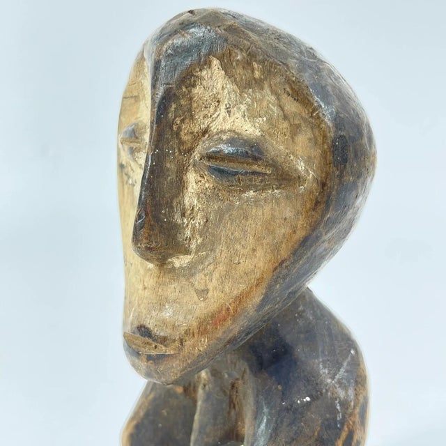 A hand-carved Lega figure originates from the Lega people in the Democratic Republic of the Congo. The figure is easily...