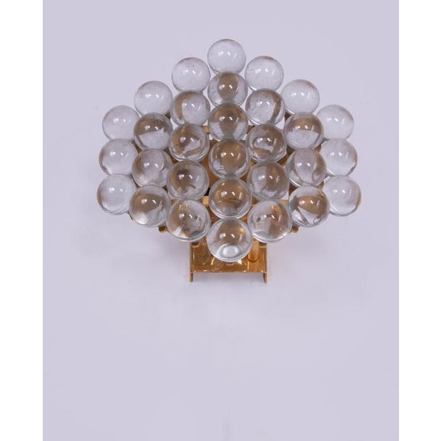 An elegant, rare wall sconce featuring numerous crystal balls mounted on a gold-plated brass frame. The bohemian crystal...