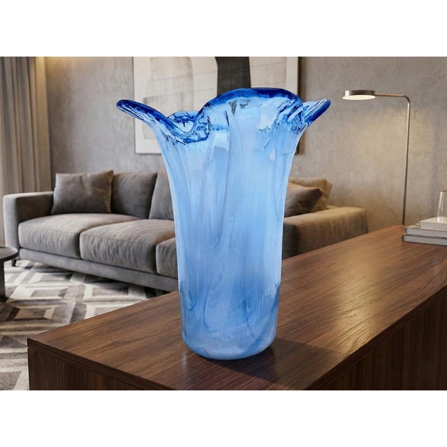The vase, handmade by Venetian glass masters, features a design characterized by an organic and sinuous shape, with a top...