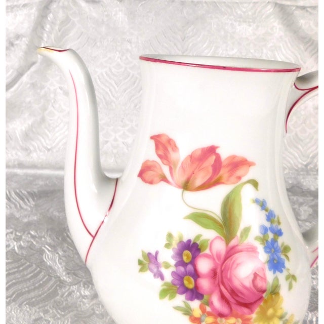 This is a white Hutschenreuther coffee pot in an unknown pattern. I have not been able to find any pattern with pink trim....
