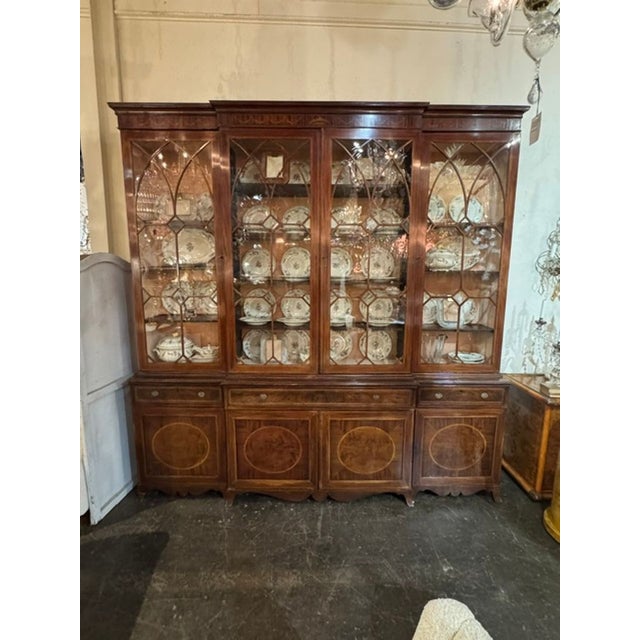 The 19th c. English George III Inlaid Mahogany Breakfront is a classic and elegant piece of furniture from the early 19th...