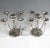 Two four-armed candleholders made of hammered and chased silver, base in a round basic shape, domed and ribbed and...