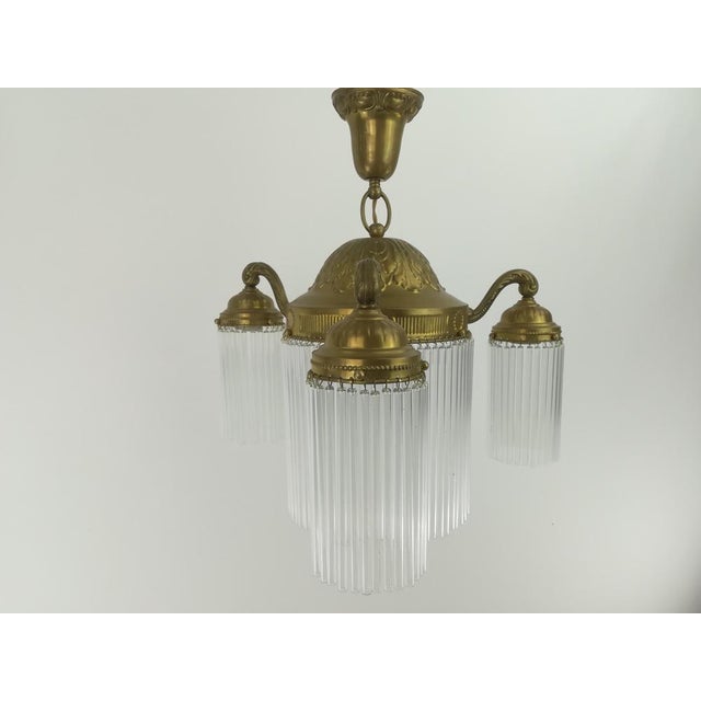 Solid brass chandelier with 4 light sources The lamp gives a cozy non-dazzling light. Surface polished. Re-electrified...