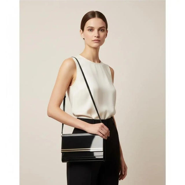 This striking 1970s Italian evening bag is a masterclass in sleek, architectural glamour, crafted from high-shine black...