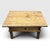 A rustic antique coffee table featuring a heavy plank top, single central drawer, and robust block legs. Originating from...