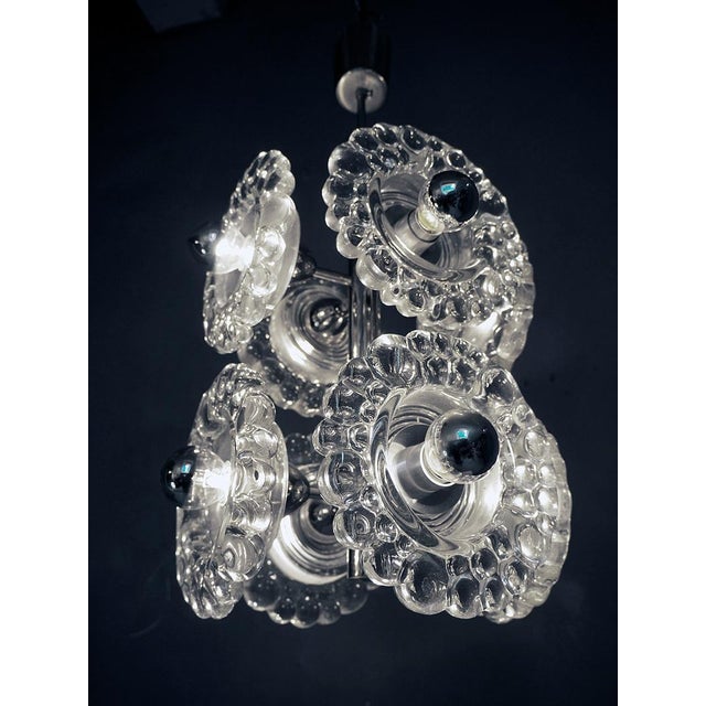 Elegant mid-century modern sputnik pendant with eight clear bubbled murano glasses on a chromed frame. Star-shaped glass...