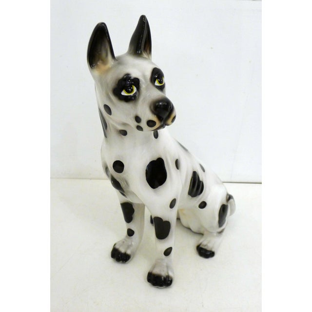 Large sculpture of a dog (Doberman, Great Dane?) with white fur and black spots, depicted seated; ceramic, 46 cm high