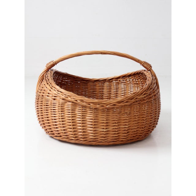 Large vintage willow market basket with a broad oval form, woven sides, and sturdy wrapped handle. Warm natural willow and...