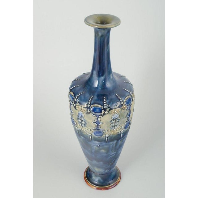Royal Doulton, England Art nouveau vase, 1920s. Slender, tall chamotte vase with blue and white hues, decorated with...